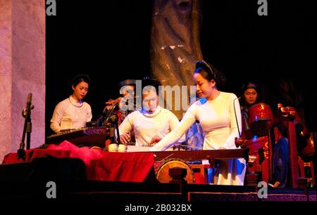 Water Puppetry oder Múa rối nước, wörtlich "Puppen, die auf Wasser tanzen", hat seinen Ursprung im Red River Delta. Die Marionetten sind aus wasserfestem Holz geschnitzt, um traditionelle ländliche Lebensstile und Fabelwesen darzustellen. Hinter der wässrigen Bühne, hüfttief im Wasser stehend, manövrieren die verborgenen Puppenspieler geschickt ihre Holzladen zur Musik eines traditionellen Orchesters. Stockfoto