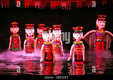 Water Puppetry oder Múa rối nước, wörtlich "Puppen, die auf Wasser tanzen", hat seinen Ursprung im Red River Delta. Die Marionetten sind aus wasserfestem Holz geschnitzt, um traditionelle ländliche Lebensstile und Fabelwesen darzustellen. Hinter der wässrigen Bühne, hüfttief im Wasser stehend, manövrieren die verborgenen Puppenspieler geschickt ihre Holzladen zur Musik eines traditionellen Orchesters. Stockfoto