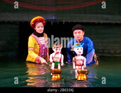 Water Puppetry oder Múa rối nước, wörtlich "Puppen, die auf Wasser tanzen", hat seinen Ursprung im Red River Delta. Die Marionetten sind aus wasserfestem Holz geschnitzt, um traditionelle ländliche Lebensstile und Fabelwesen darzustellen. Hinter der wässrigen Bühne, hüfttief im Wasser stehend, manövrieren die verborgenen Puppenspieler geschickt ihre Holzladen zur Musik eines traditionellen Orchesters. Stockfoto