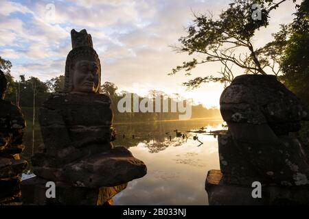 Asuras werden in der Regel in Opposition zu Devas (wohlwollende Götter oder Engel) gesehen. Angkor Thom, was 'Die Große Stadt' bedeutet, liegt 1,5 km nördlich von Angkor Wat. Es wurde im späten 12. Jahrhundert von König Jayavarman VII. Erbaut und erstreckt sich über eine Fläche von 9 km², innerhalb derer sich mehrere Denkmäler aus früheren Epochen sowie solche befinden, die von Jayavarman und seinen Nachfolgern eingerichtet wurden. Es wird angenommen, dass es eine Bevölkerung von 80.000 bis 150.000 Menschen gegeben hat. Im Zentrum der Stadt befindet sich Jayavarmans Staatstempel, der Bayon, mit den anderen wichtigen Stätten, die sich unmittelbar um den Siegesplatz gruppieren Stockfoto