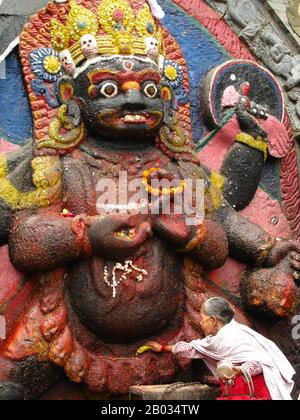 Der Kala Bhairav oder Black Bhairav ist eine 3 m hohe Statue, die eine schwerkelnde, terroristische Manifestation von Shiva darstellt, die auf ein unglückliches Opfer trampelt. Lokale Lore hat es, dass das Bild auf dem Berg Nagarjun am westlichen Rand des Kathmandu-Tals gefunden und von König Pratapa Malla an seinen heutigen Ort gebracht wurde. Nachdem das Bild auf dem Durbar-Platz eingerichtet war, mussten königliche Höflinge vor ihm Treueeiden schwören und Zeugen in Strafverfahren mussten in ihrer Anwesenheit Aussagen. Man glaubte, dass jeder, der Lügen vor Kala Bhairav erzählt, sofort sterben würde. Kala Bhaira Stockfoto