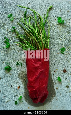 Hochwinkeliger Blick auf einen Haufen roher Spargel auf einer strukturierten blassgrünen Oberfläche Stockfoto