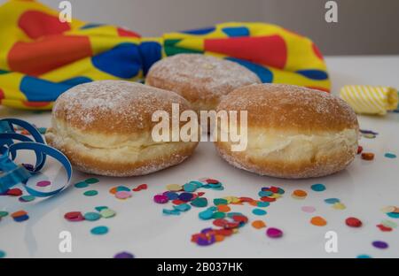 Nahaufnahme von drei Donuts mit Karnevalsschmuck um sie herum Stockfoto