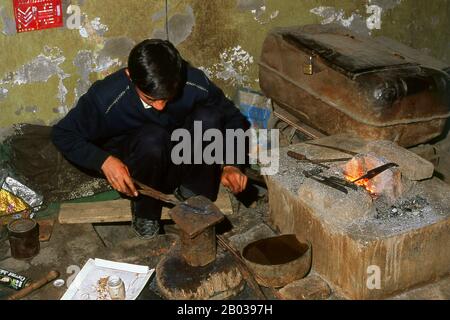 Die kleine von Uiguren dominierte Oase Yengisar (Yingjisha) ist in der gesamten westchinesischen Provinz Xinjiang für die Herstellung von handgefertigten Messern bekannt. Die Kleine Messerfabrik (Pichak Chilik Karakhana/Xiadaochang) beschäftigt erfahrene Handwerker vor Ort, die feine Messer mit eingelegten Griffen herstellen. Fast jeder uigurische Mann trägt ein Messer, sowohl als Zeichen der Manschaft als auch für den utilitareren Zweck, Melonen aufzuschneiden, und die wertvollsten (und teuersten) stammen aus Yengisar. Stockfoto