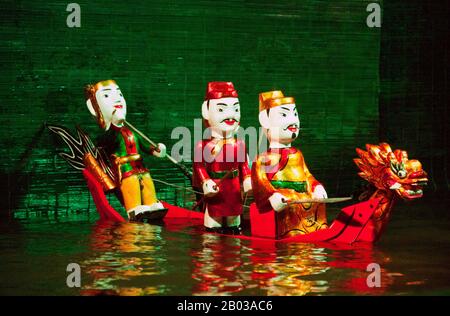 Water Puppetry oder Múa rối nước, wörtlich "Puppen, die auf Wasser tanzen", hat seinen Ursprung im Red River Delta. Die Marionetten sind aus wasserfestem Holz geschnitzt, um traditionelle ländliche Lebensstile und Fabelwesen darzustellen. Hinter der wässrigen Bühne, hüfttief im Wasser stehend, manövrieren die verborgenen Puppenspieler geschickt ihre Holzladen zur Musik eines traditionellen Orchesters. Stockfoto