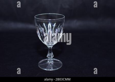 Verspottes Design mit elegantem und traditionellem Getränkegeschirr/Trinkglas und Glas für Wein oder Saft, transparent isoliert auf schwarzer Hintergrundvorlage Stockfoto