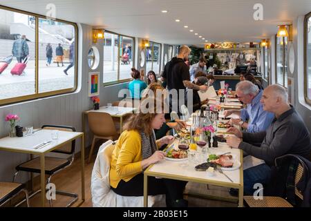 Kunden, die eine Mahlzeit in den Kanalbattern Darcie und May Green, einem schwimmenden Restaurant, Grand Union Canal, Paddington London UK, essen Stockfoto