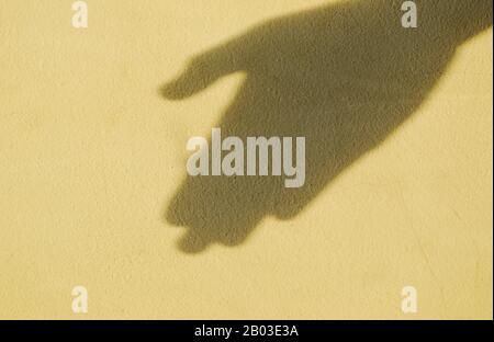 Schatten der menschlichen Hand auf der alten Zementwand Stockfoto