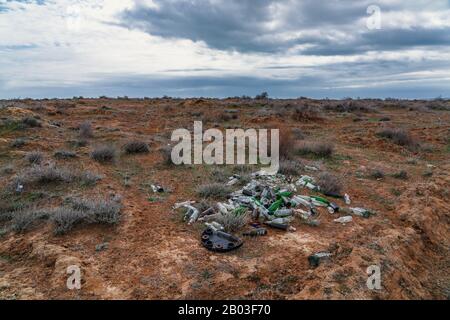 Stapel von Glasflaschen im Feld, Umweltverschmutzung Stockfoto