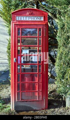 CARRON VILLAGE MORAY SCOTLAND EINE ALTE ROTE TELEFON-BOX ENTHÄLT SNACKS UND GETRÄNKE FÜR WANDERER AUF DEM SPEYSIDE WAY LONG DISTANCE TRAIL Stockfoto