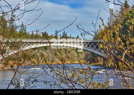 DAS DORF CARRON MORAY SCOTLAND HAZEL BIETET EINEN BLICK VOM FLUSS BANK AUF DIE EINZIGARTIGE STRASSE CARRON UND DIE ALTE EISENBAHNBRÜCKE, DIE DEN FLUSS SPEY ÜBERQUERT Stockfoto