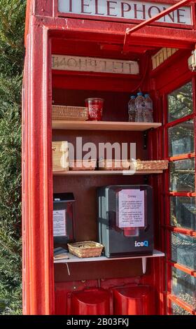 CARRON VILLAGE MORAY SCOTLAND RED TELEPHONE BOX INNENEINRICHTUNG ENTHÄLT SNACKS UND GETRÄNKE FÜR WANDERER AUF DEM SPEYSIDE WAY LONG DISTANCE TRAIL Stockfoto