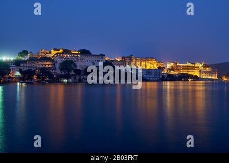 Nacht über den Pichola-See auf den beleuchteten Stadtpalast und den Taj Fateh Prakash Palast von Udaipur, Rajasthan, Indien Stockfoto