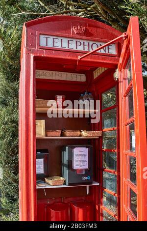 CARRON VILLAGE MORAY SCOTLAND RED TELEPHONE BOX DAS INTERIEUR ENTHÄLT SNACKS UND GETRÄNKE FÜR WANDERER AUF DEM SPEYSIDE WAY LONG DISTANCE TRAIL Stockfoto