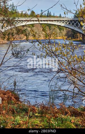 CARRON VILLAGE MORAY SCOTLAND SCHNEEFÄLLE UND HAZEL BIETET EINEN BLICK VON DER BANK AUF DIE EINZIGARTIGE CARRON ROAD UND DIE ALTE EISENBAHNBRÜCKE, DIE DEN FLUSS S ÜBERQUERT Stockfoto