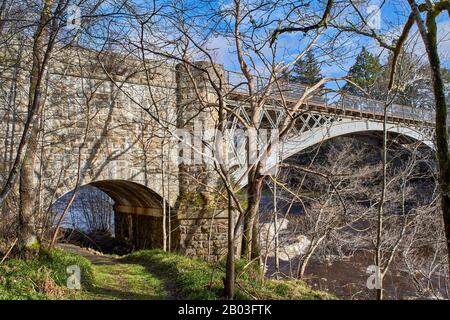 CARRON VILLAGE MORAY SCOTLAND BÄUME AM UFER UMGEBEN DIE EINZIGARTIGE CARRON ROAD UND DIE ALTE EISENBAHNBRÜCKE, DIE DEN FLUSS SPEY ÜBERQUERT Stockfoto