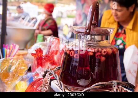Transparente Teekanne aus Glas mit Obsttee beim fest der Straßennahrung mit Himbeere Stockfoto