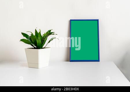 Minimalistischer Stil des Bilderrahmens im Regal, Mockup-Design, grüner Chroma-Schlüssel Stockfoto