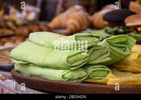 Shawrma in Pita Brot wird auf dem Festival der Straßennahrung mit Copyspace mit Grüns und Gemüse bestreut Stockfoto