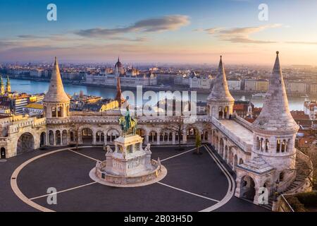 Budapest, Ungarn - Die berühmte Fischerbastei bei Sonnenaufgang mit Statue von König Stephan I. und dem ungarischen Parlament im Hintergrund Stockfoto