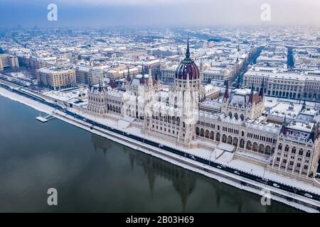 Budapest, Ungarn - Blick Auf das schneebedeckte Parlament Ungarns und die Skyline von Pest zur Winterzeit Stockfoto