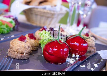 Molekulare Küche Paste in Form von Gemüse mit Kräutern auf dunklem Teller Stockfoto