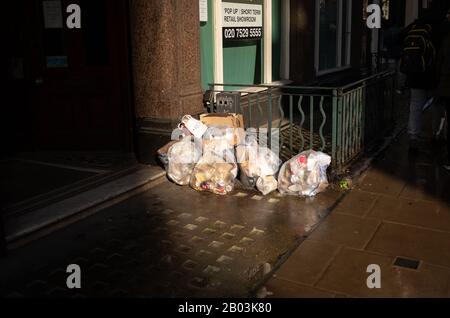 Abfallbeutel auf dem Straßenbelag recyceln Stockfoto