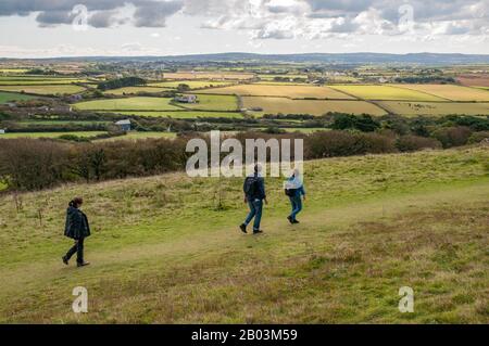 Drei Spaziergänger, die auf Wanderwegen in der Nähe von St Agnes Head an der Heritage Coast in Cornwall, England, spazieren. Stockfoto