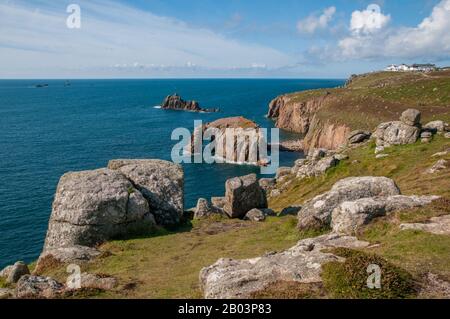 Blick nach Norden über die Buchten der dramatischen Küste von Cornwall zum Enys Dodnan Arch und zum Land's End Visitors' Center. Stockfoto