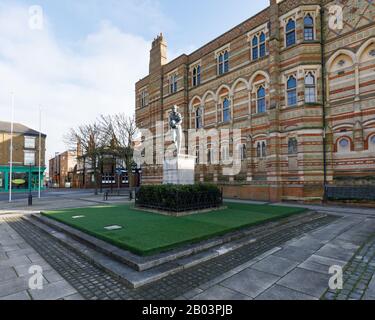 Rugby, Großbritannien, Februar 2020: Statue von William Webb Ellis, der außerhalb der Rugby School steht, wo er einen Ball aufgenommen und das Spiel erschaffen haben soll. Stockfoto