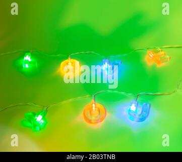 Mehrfarbige Liebe Sie Worte in einer Reihe von Lichtern mit grünem Hintergrund Stockfoto