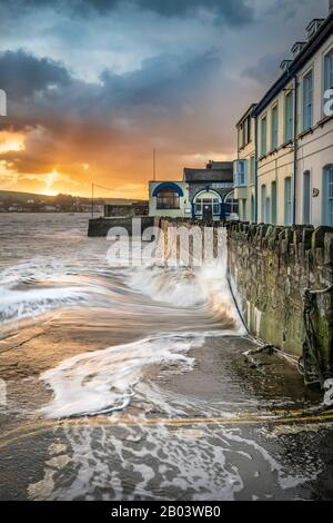 Bei Flut auf dem Fluss Torridge stürzen Wellen gegen den Seewall am West Quay in Appledore, Nord-Devon. Stockfoto