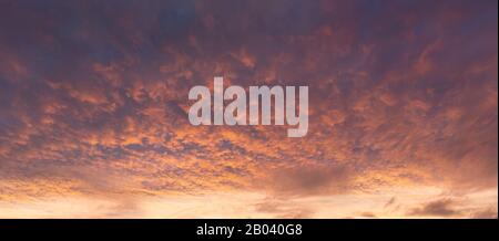 Panorama der dramatischen Wolkenlandschaft bei Sonnenuntergang mit roten Wolken am Himmel Stockfoto