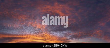 Panorama der Wolkenlandschaft bei Sonnenuntergang mit roten Wolken am Himmel Stockfoto