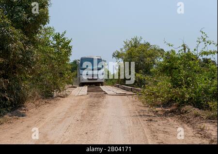 Bus, der eine der Brücken des Transpantaneira Highway im nördlichen Pantanal, Provinz Mato Grosso in Brasilien, überquert. Stockfoto