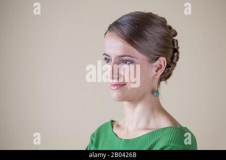 Lächelnde Frau mit Ohrring und Haarbun Stockfoto