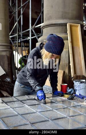 Frau Buntglas arbeitende Reinigungsplatte aus Klarglas bei der Altbau-Sanierung. Arbeiten vor Ort. Stockfoto