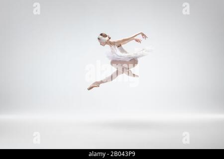 Fliegender Vogel. Elegante klassische Ballerina, die isoliert auf weißem Studiohintergrund tanzt. Frau in zärtlicher Kleidung wie ein weißer Schwan. Das Anmut-, Künstler-, Bewegungs-, Action- und Bewegungskonzept. Stockfoto