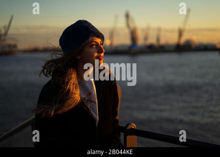 Junges Mittelost-Mädchen-Modell bei Sonnenuntergang im Hamburger Hafen. Stockfoto