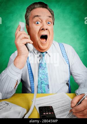Ein Geschäftsmann, der einen überraschenden Telefonanruf entgegennimmt Stockfoto