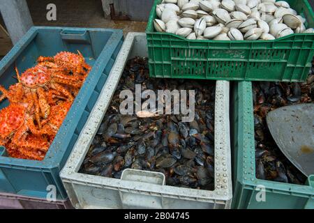 Marktszene mit Muscheln, Muscheln und King-Krabben zum Verkauf in der Markthalle in Angelmo, Puerto Montt im Süden Chiles. Stockfoto