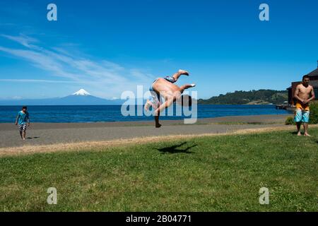 Junger Mann bricht auf der Seepromenade in Frutillar, einer kleinen Stadt am Llanquihue-See im Lake District in der Nähe von Puerto Montt, Chile mit Osorno Stockfoto