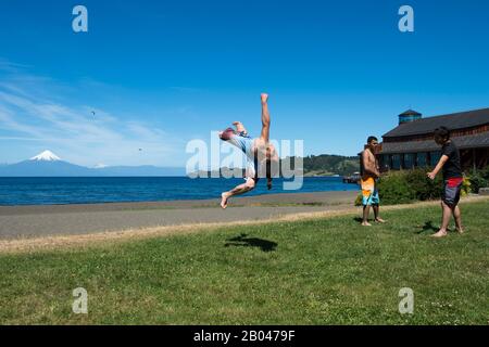 Junger Mann bricht auf der Seepromenade in Frutillar, einer kleinen Stadt am Llanquihue-See im Lake District in der Nähe von Puerto Montt, Chile mit Osorno Stockfoto