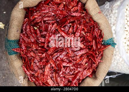 Rote Paprika in einer Leinwandtasche auf einem Straßenmarkt in Indien Stockfoto