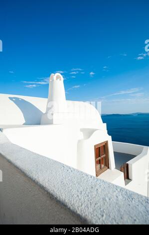 Helle abstrakte Sicht auf die weiß getünchte griechische Inselarchitektur mit einem ruhigen blauen Horizont im Mittelmeer in Santorini, Griechenland Stockfoto