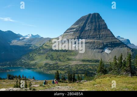 Blick auf den Bearhat Mountain über Dem Hidden Lake am Logan Pass im Glacier National Park, Montana, Vereinigte Staaten, mit Menschen im Vordergrund. Stockfoto