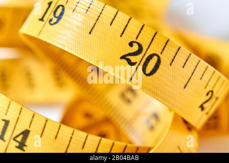 Gelber Farbzentimeter mit schwarzen Zahlen zur Messung von Länge und Breite auf weißem Hintergrund. Messband des Schneiders für Ihr Design. Clo Stockfoto