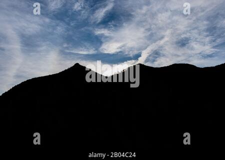 Der Silhouettenumriss der Berge gegen den klaren blauen Himmel im Winter Stockfoto