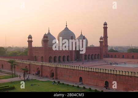 Sonnenuntergang über den Domen der Badshahi Moschee (Kaiser-Moschee), die 1673 vom Moghul-Kaiser Aurangzeb in Lahore, Pakistan, erbaut wurde Stockfoto