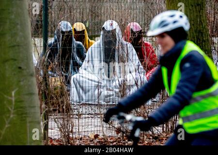 Berlin, Deutschland. Februar 2020. "Die Wächter der Zeit" des österreichischen Künstlers Manfred Kielnhofer steht im Tiergarten auf einem umzäunten Gelände, an dem eine Frau mit dem Fahrrad vorbeifährt. Credit: Christoph Soeder / dpa / Alamy Live News Stockfoto